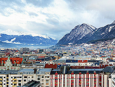 Panorama von der Stadtlandschaft von Innsbruck, Österreich, an einem kalten Wintermorgen mit Schnee und Wolken