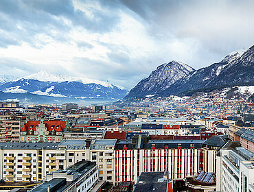 Panorama von der Stadtlandschaft von Innsbruck, Österreich, an einem kalten Wintermorgen mit Schnee und Wolken
